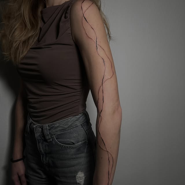 Fine line tetování na paži, propletené linky